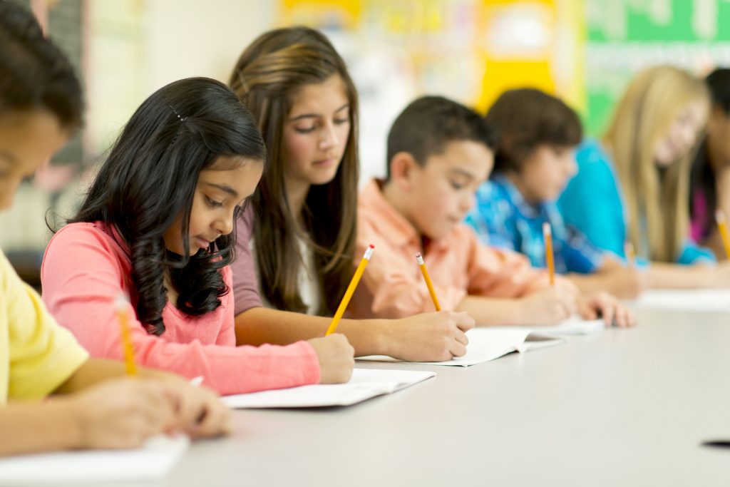 Elementary school students writing in their classroom.